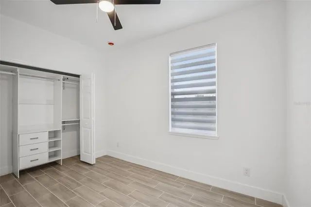 a view of an empty room with cabinet and a window