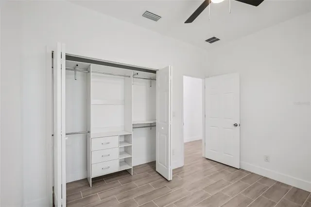 a view of walk in closet with wooden floor