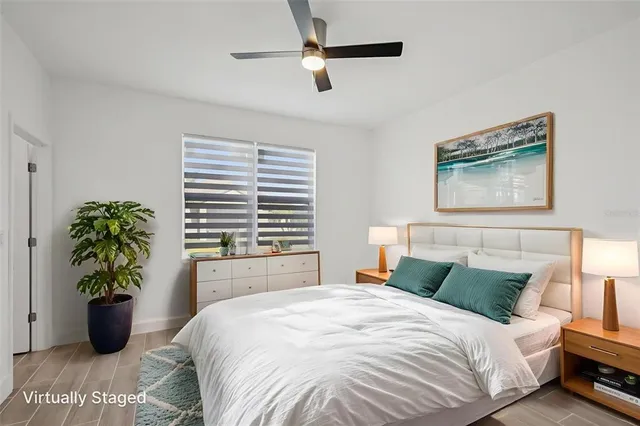 a bedroom with a bed and a potted plant