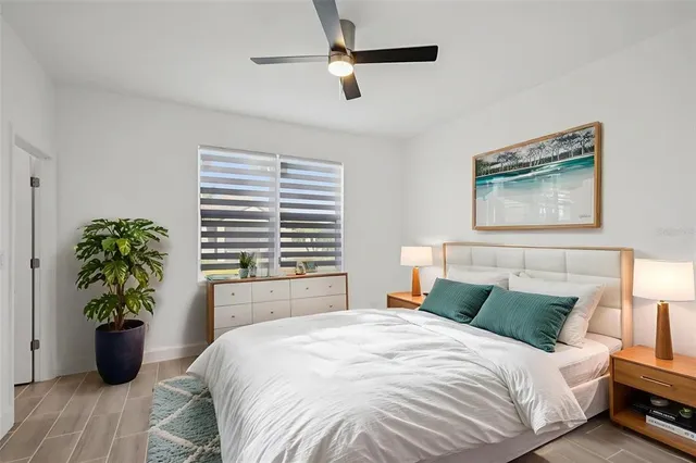 a bedroom with a bed and a potted plant