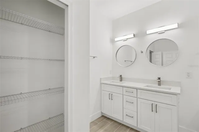 a bathroom with a double vanity sink and a mirror