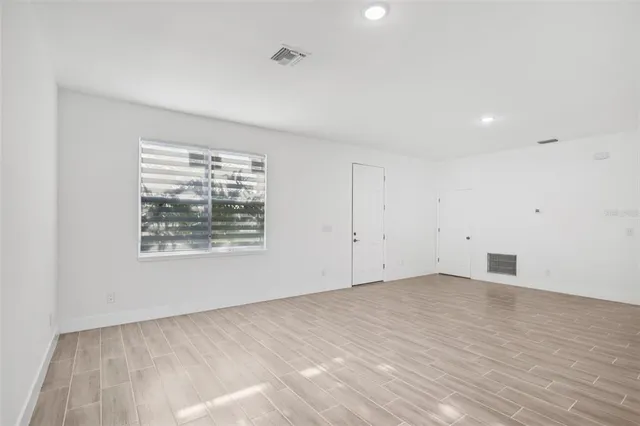 wooden floor in an empty room with a window