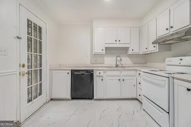 a kitchen with granite countertop white cabinets and white appliances