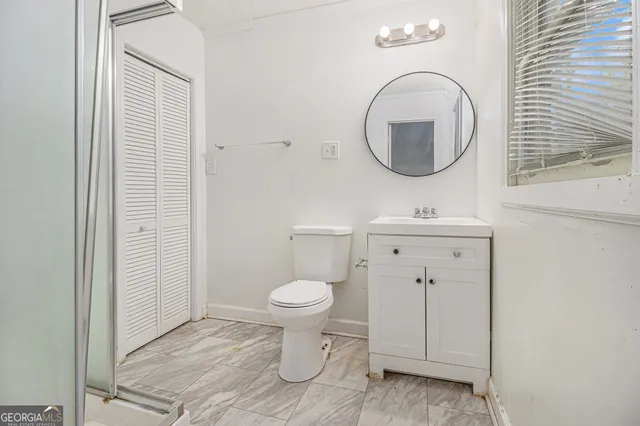 a bathroom with a toilet sink and mirror