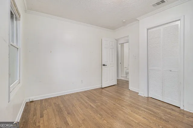 a view of an empty room with wooden floor