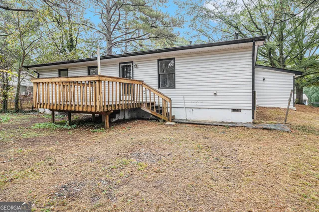 a view of a house with a yard and deck