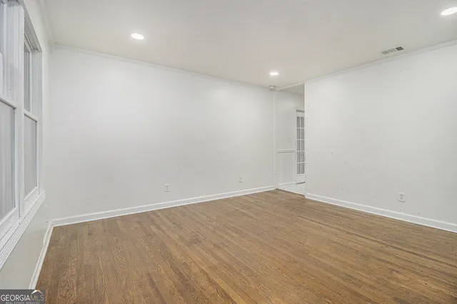 an empty room with wooden floor and white walls