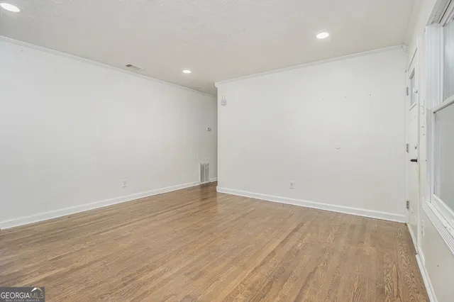 a view of an empty room with wooden floor