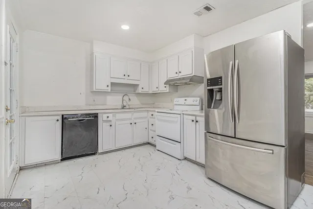 a kitchen with cabinets stainless steel appliances and a counter space