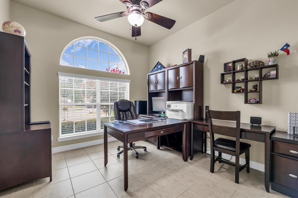 910 Springdale Lane Lorena, TX 76655 - Photo 22 of 39 Room featuring a large arched window with grid details, a ceiling fan with integrated lighting, and neutral-toned wall paint