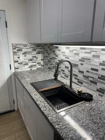 a kitchen with granite countertop a sink and a stove