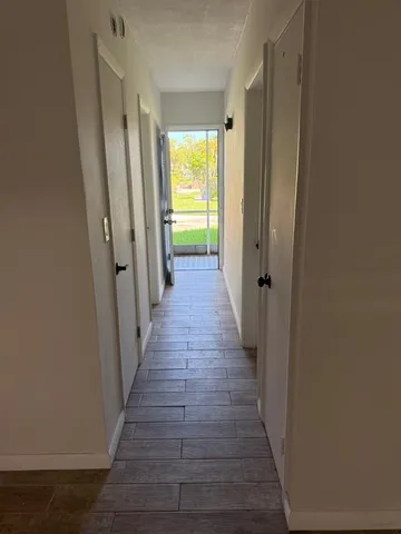 a view of a hallway with wooden floor
