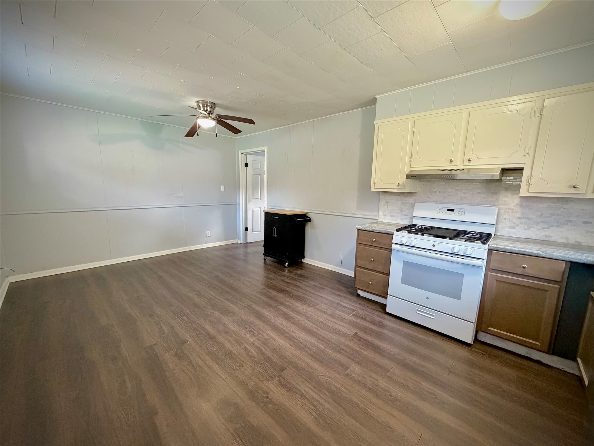 3124 30th Street Port Arthur, TX 77642 - Photo 15 of 25 a kitchen with granite countertop a stove a cabinets and wooden floor