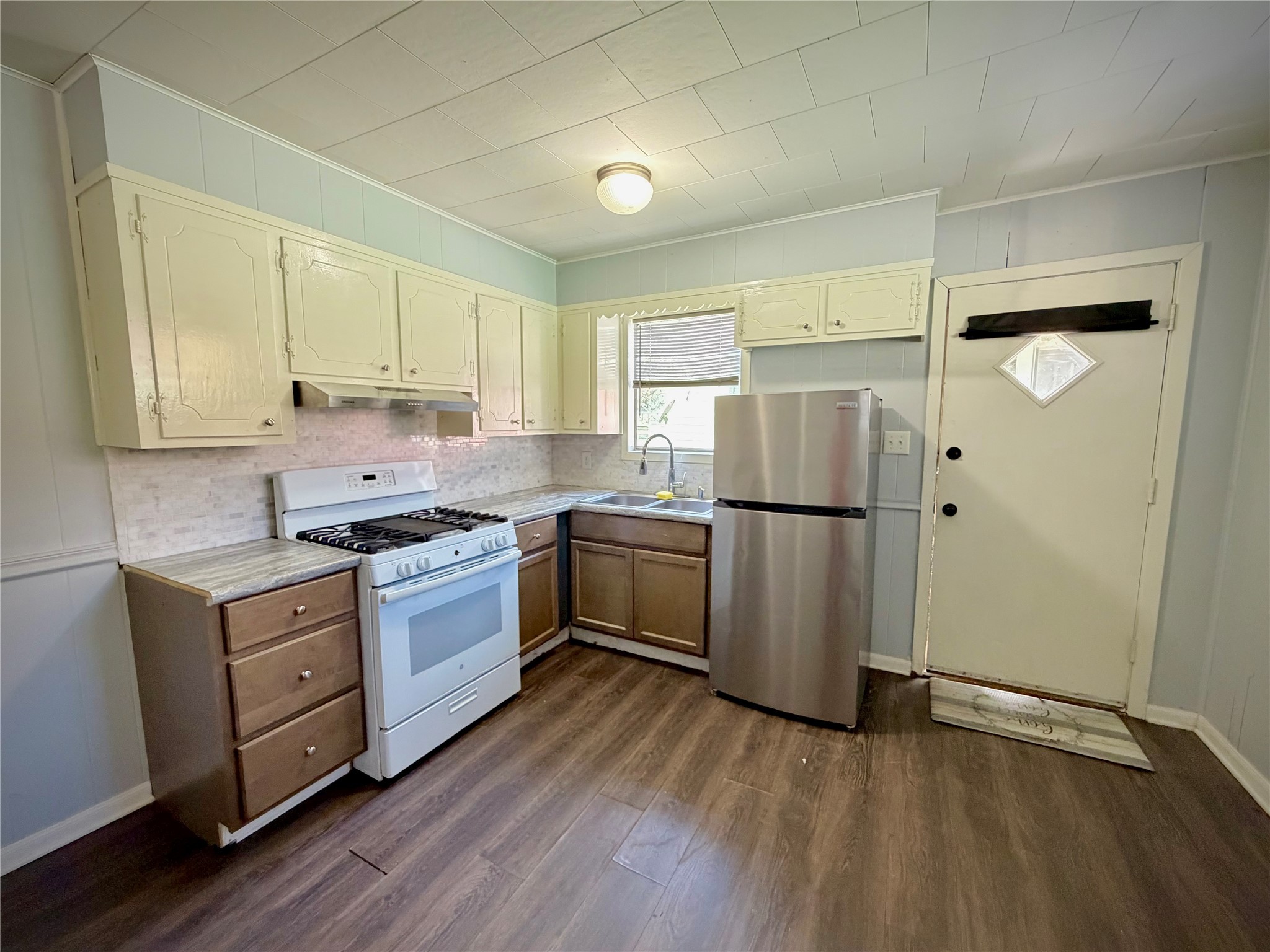 3124 30th Street Port Arthur, TX 77642 - Photo 16 of 25 a kitchen with a refrigerator stove and wooden cabinets