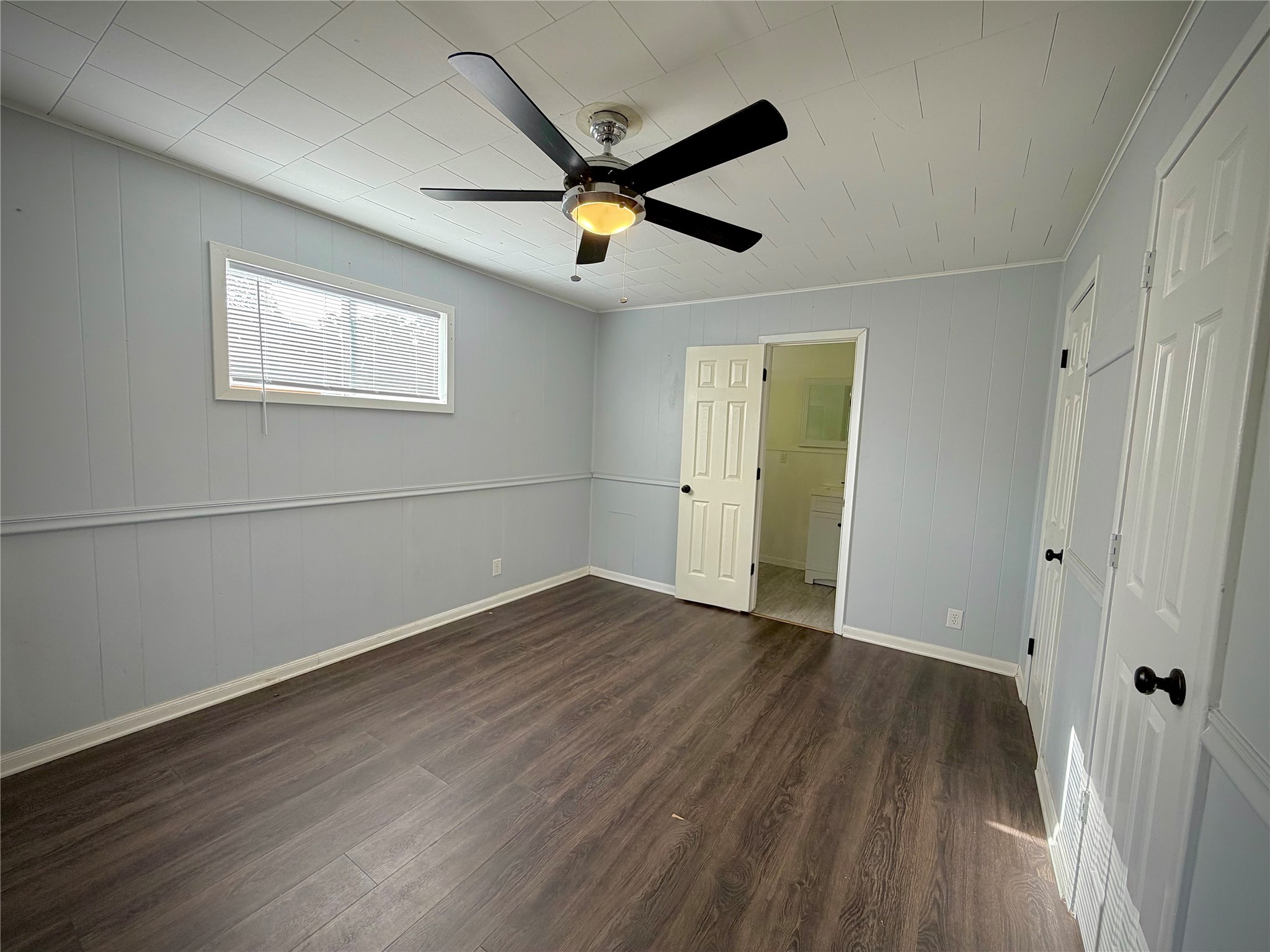 3124 30th Street Port Arthur, TX 77642 - Photo 17 of 25 an empty room with wooden floor and a ceiling fan