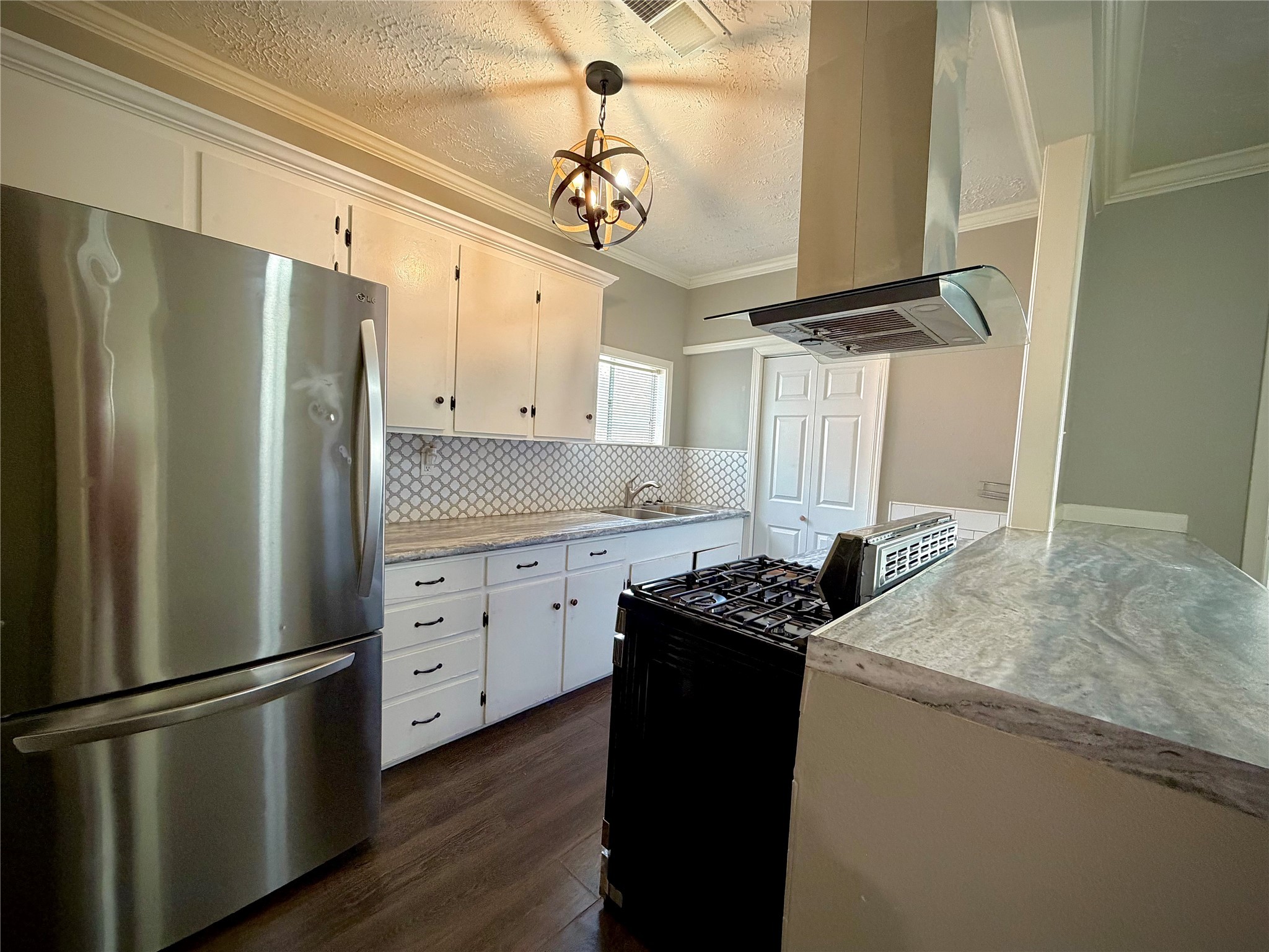 3124 30th Street Port Arthur, TX 77642 - Photo 4 of 25 a kitchen with stainless steel appliances granite countertop a refrigerator sink and white cabinets