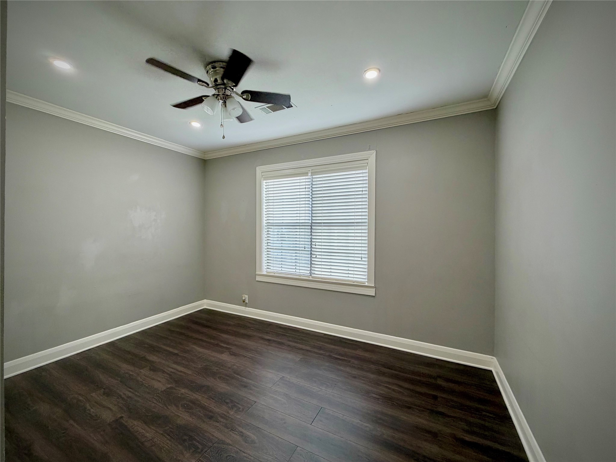 3124 30th Street Port Arthur, TX 77642 - Photo 7 of 25 an empty room with wooden floor ceiling fan and windows
