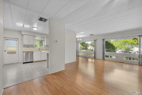 a view of a kitchen with wooden floor and a window