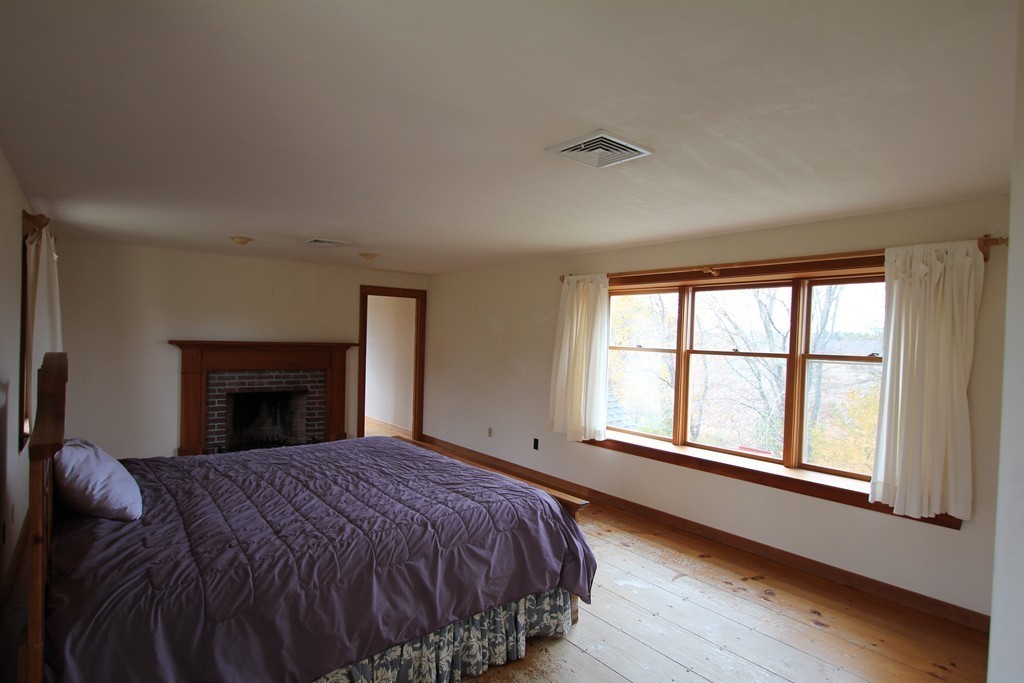 340 Still River Road Harvard, MA 01451 - Photo 7 of 13 a bed sitting in a bedroom next to a window