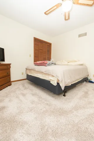 a spacious bedroom with a bed and cabinet