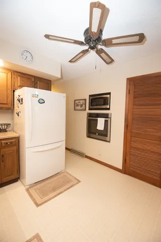 a white refrigerator freezer and a stove sitting inside of a kitchen