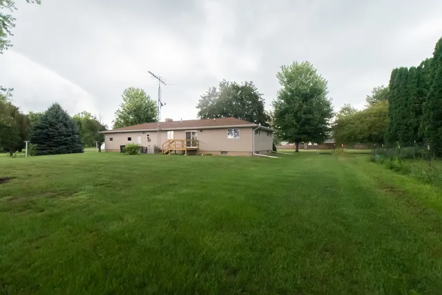 a view of a house with a yard and sitting area