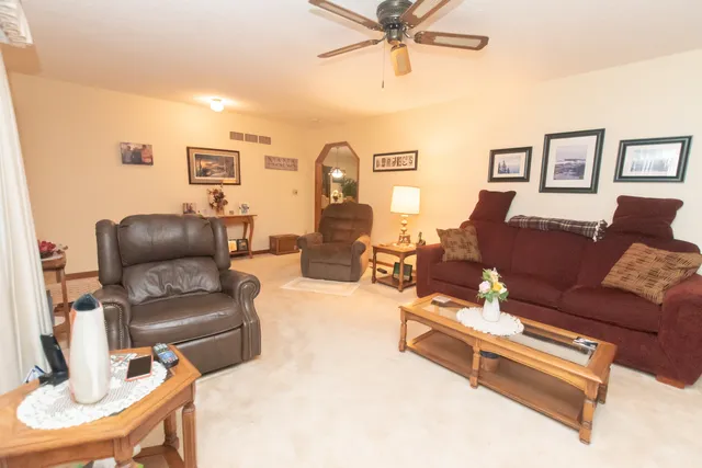 a living room with furniture and a view of kitchen