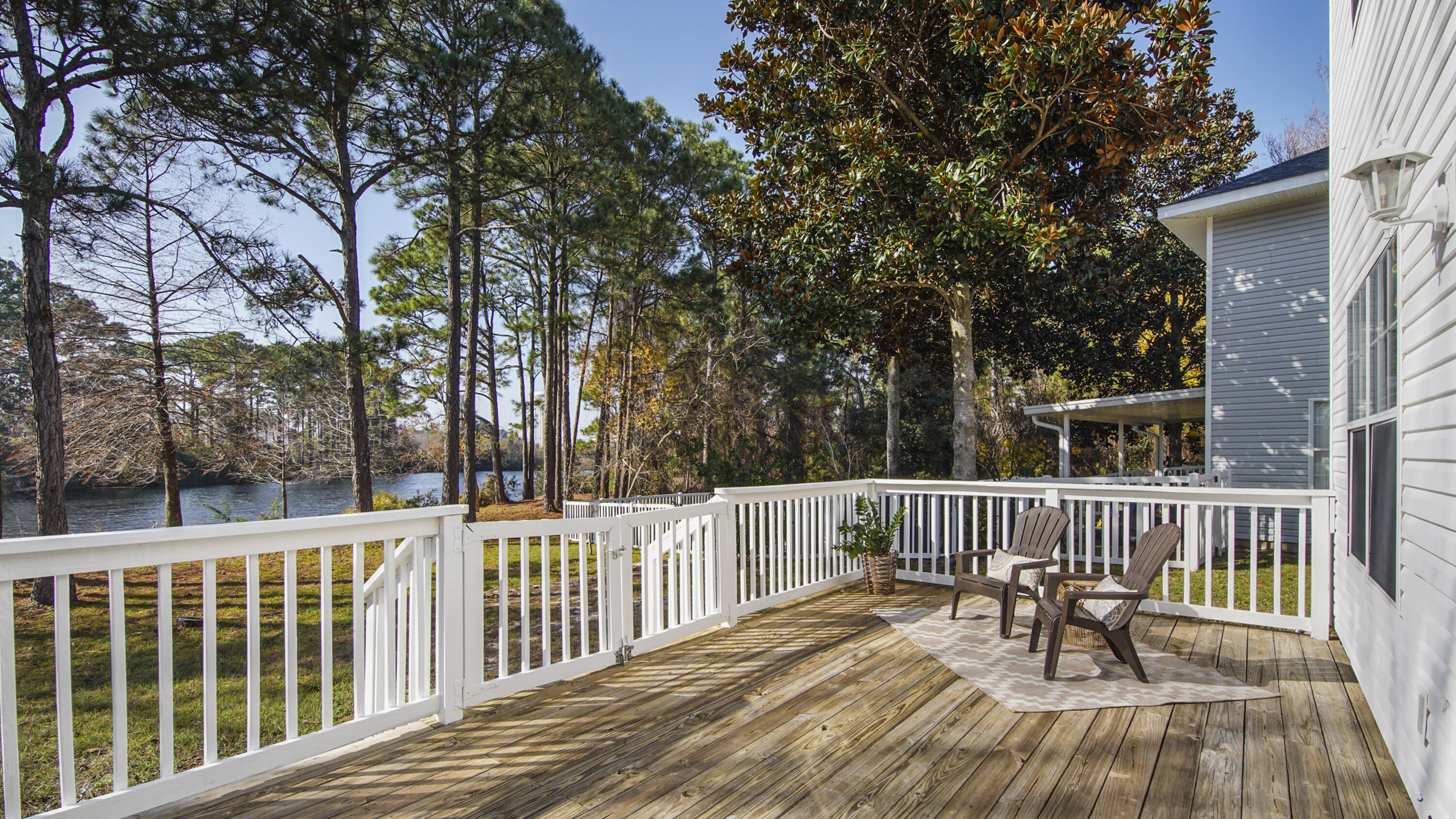 302 Liriope Loop Destin, FL 32541 - Photo 5 of 59 a view of a wooden deck with a bench and trees