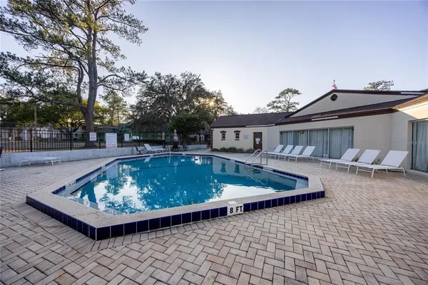 a view of a white house with a swimming pool and sitting area