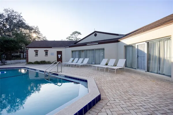 a view of a house with pool and chairs