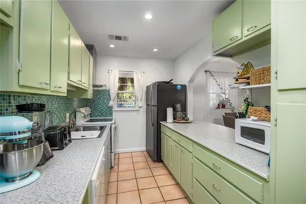 a kitchen with refrigerator and cabinets