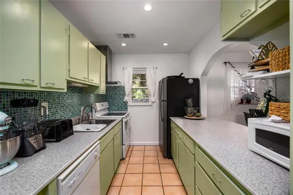 a kitchen with stainless steel appliances granite countertop a sink a stove and a refrigerator
