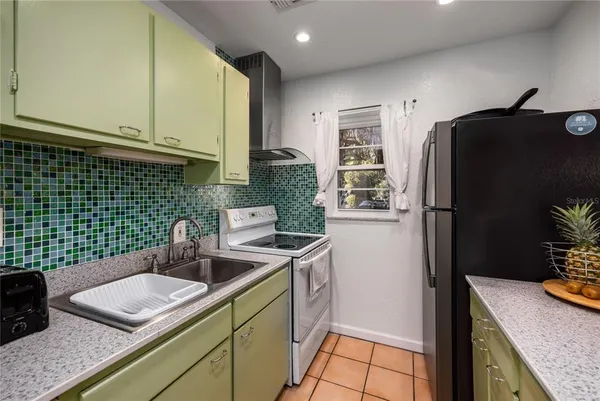 a kitchen with a sink a refrigerator and cabinets
