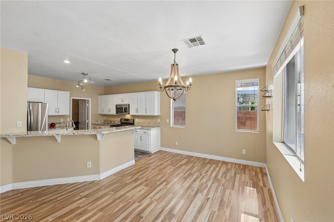 1727 Millstream Way Henderson, NV 89074 - Photo 13 of 46 Granite counters and stainless steel appliances complete this bright, open-concept kitchen and dining space.