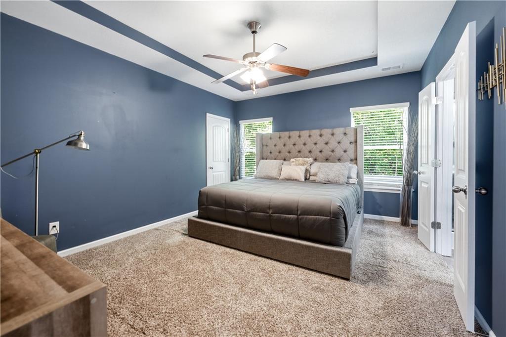 291 Boulder Run Hiram, GA 30141 - Photo 20 of 46 a bedroom with a large bed and a chandelier