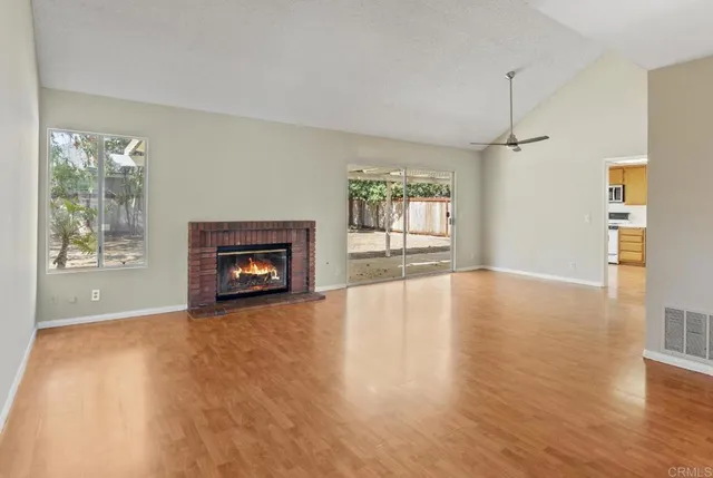 a view of an empty room with a window and fireplace