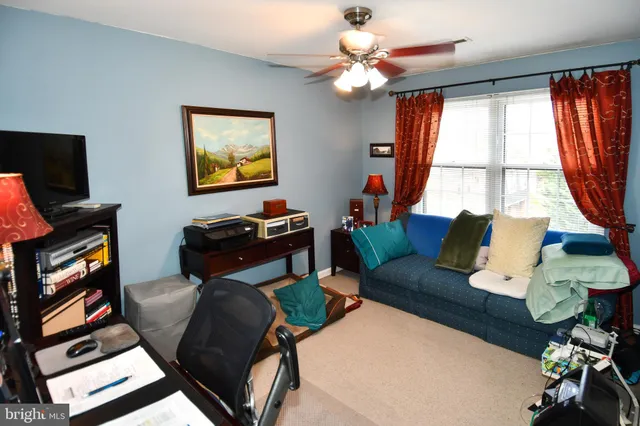 a living room with furniture a flat screen tv and a floor to ceiling window