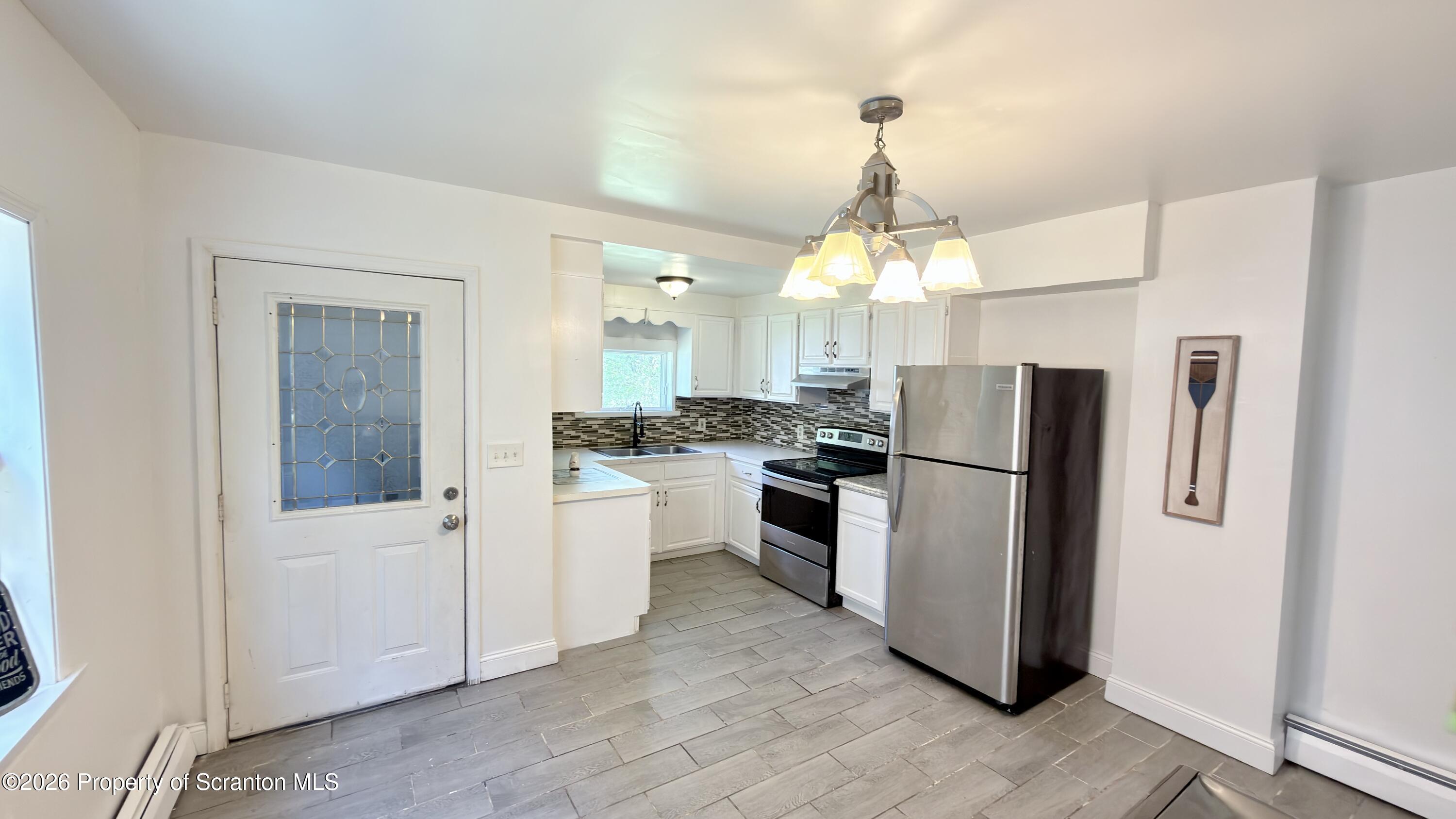 2115-2117 Wayne Avenue Scranton, PA 18508 - Photo 12 of 44 a kitchen with refrigerator a sink and cabinets