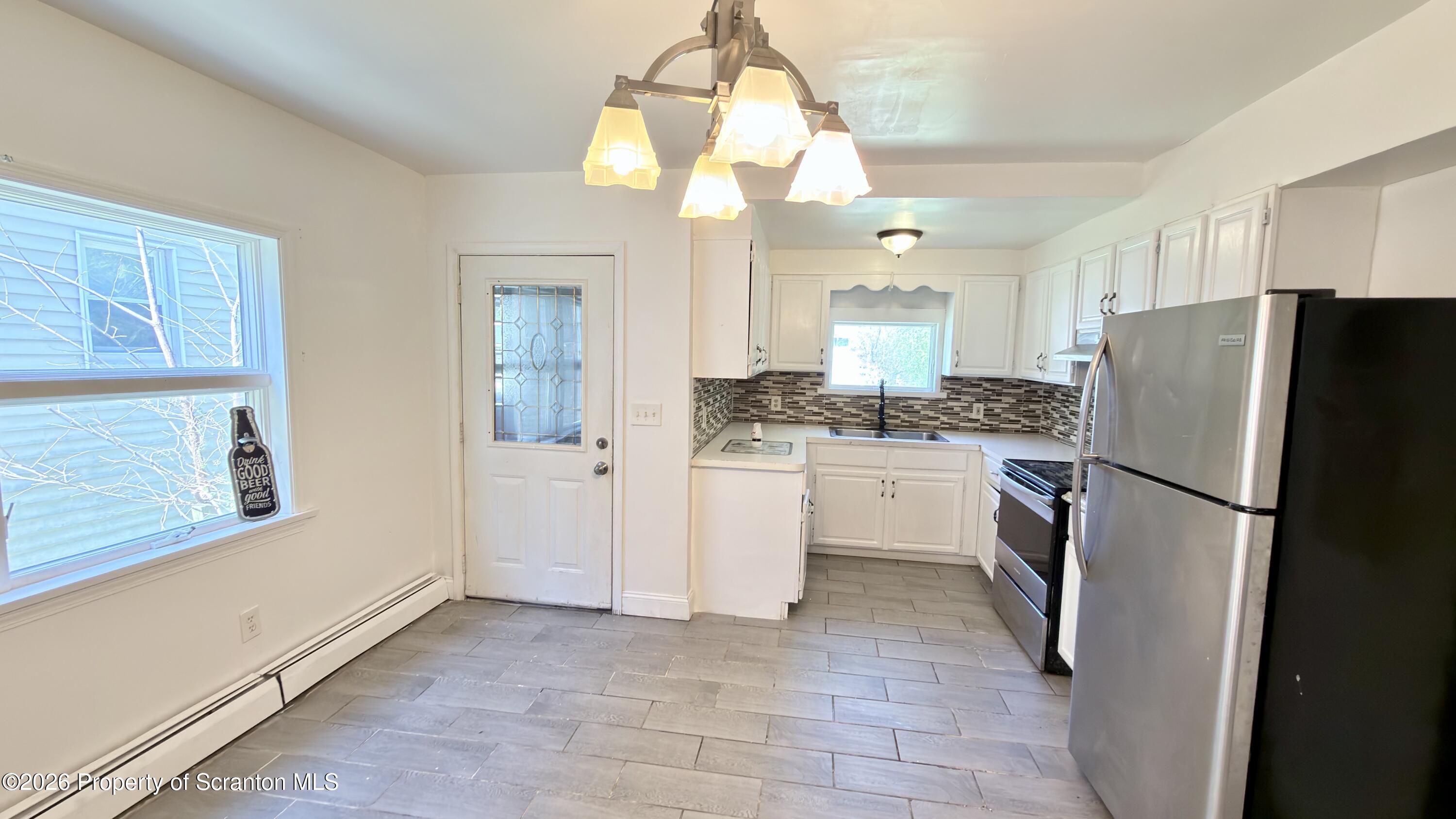 2115-2117 Wayne Avenue Scranton, PA 18508 - Photo 13 of 44 a kitchen with a refrigerator a stove top oven and cabinets