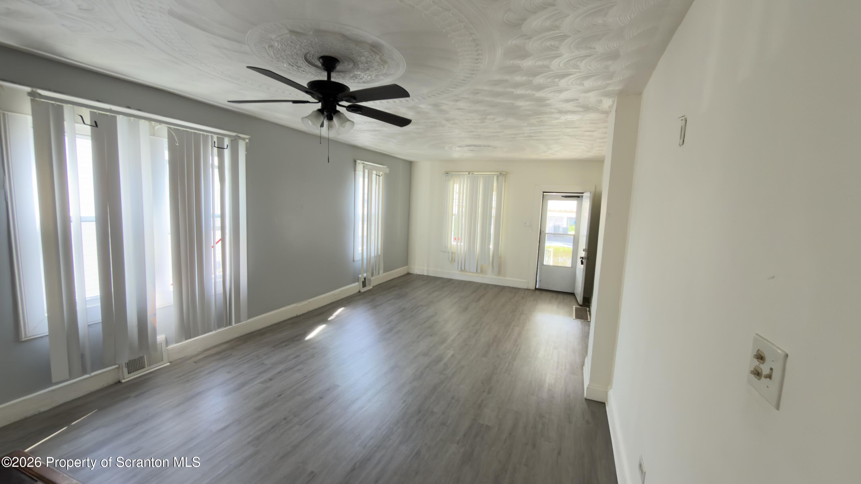 2115-2117 Wayne Avenue Scranton, PA 18508 - Photo 21 of 44 a view of a livingroom with wooden floor and a ceiling fan