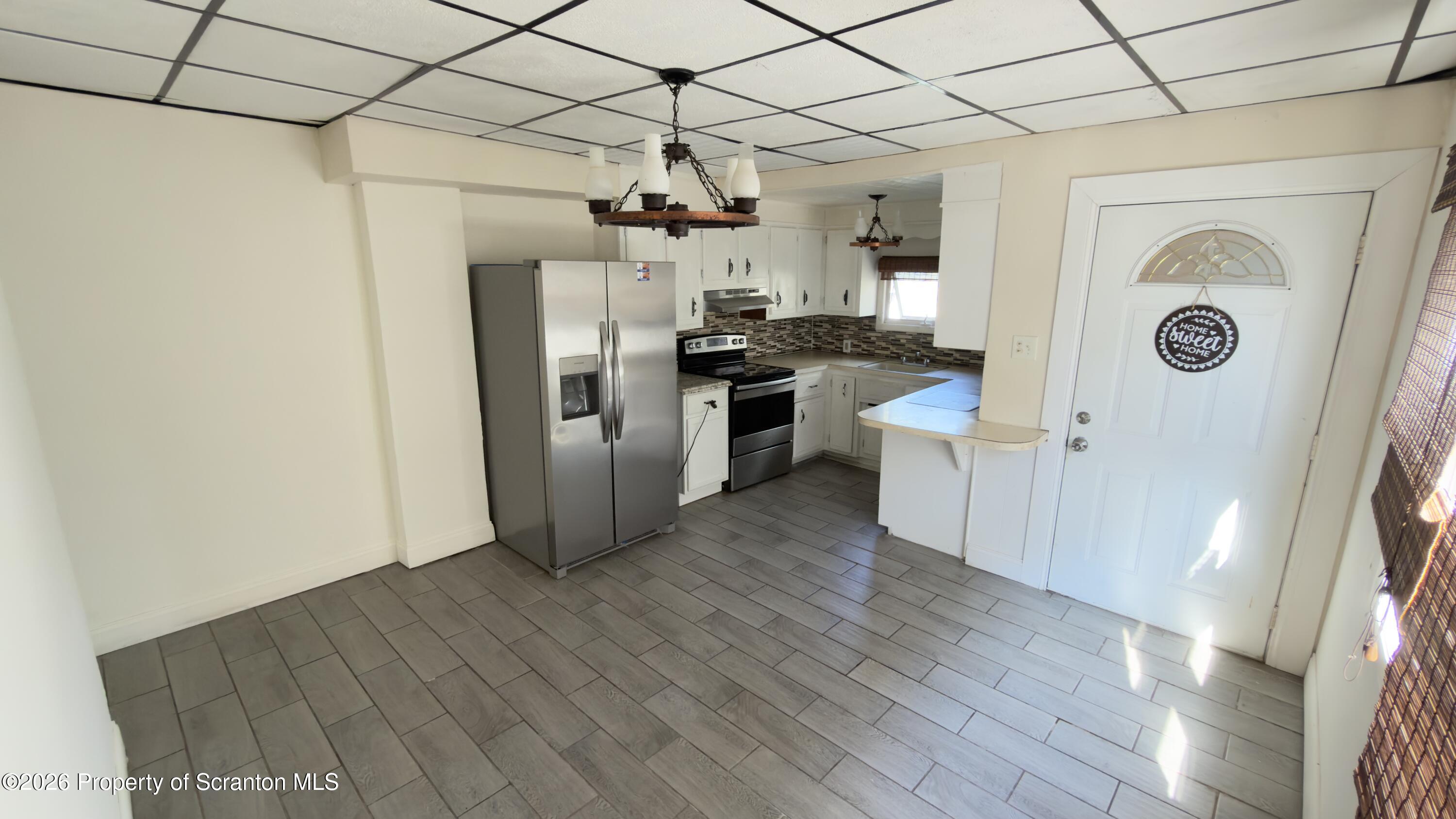 2115-2117 Wayne Avenue Scranton, PA 18508 - Photo 25 of 44 a kitchen with a refrigerator a stove top oven a sink and wooden floor