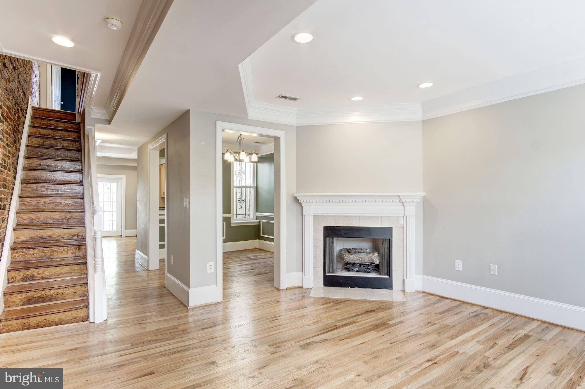 1414 D Street Northeast Washington, DC 20002 - Photo 2 of 25 a view of an empty room with wooden floor fireplace and a window