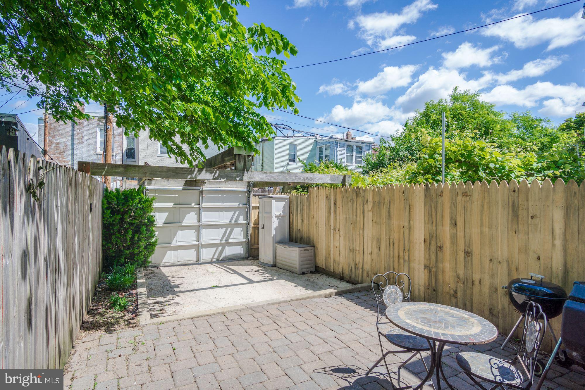 1414 D Street Northeast Washington, DC 20002 - Photo 19 of 25 a view of a backyard with table and chairs and a large tree