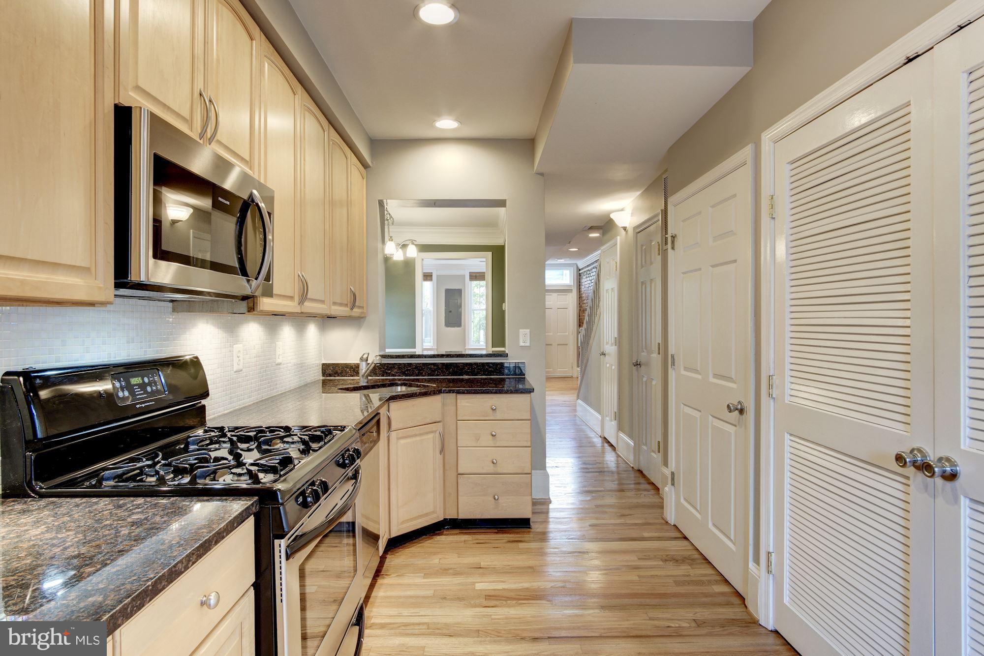 1414 D Street Northeast Washington, DC 20002 - Photo 8 of 25 a kitchen with stainless steel appliances granite countertop a stove and a refrigerator