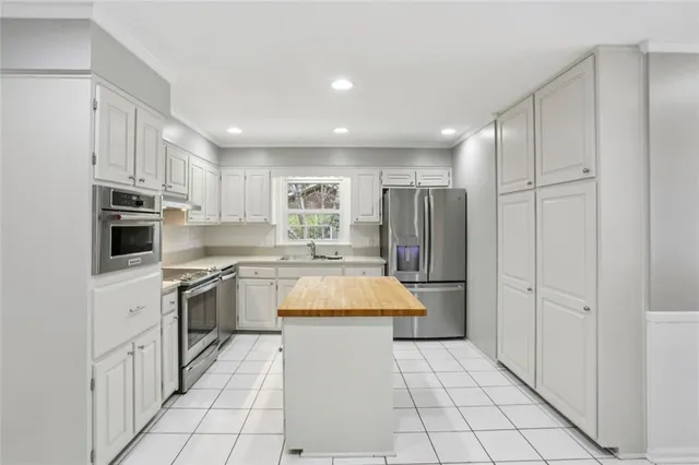 a kitchen with stainless steel appliances granite countertop a refrigerator and a stove top oven