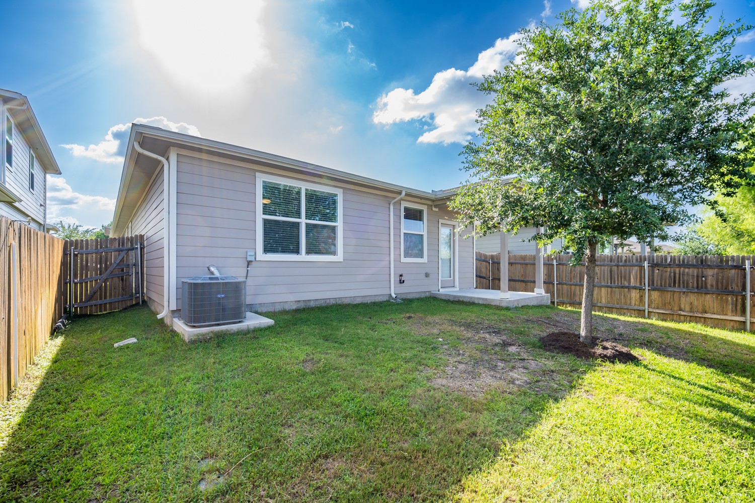 10801 Meris Lane Austin, TX 78754 - Photo 17 of 18 A well-maintained backyard with a verdant lawn and a charming tree, offering a private outdoor retreat.