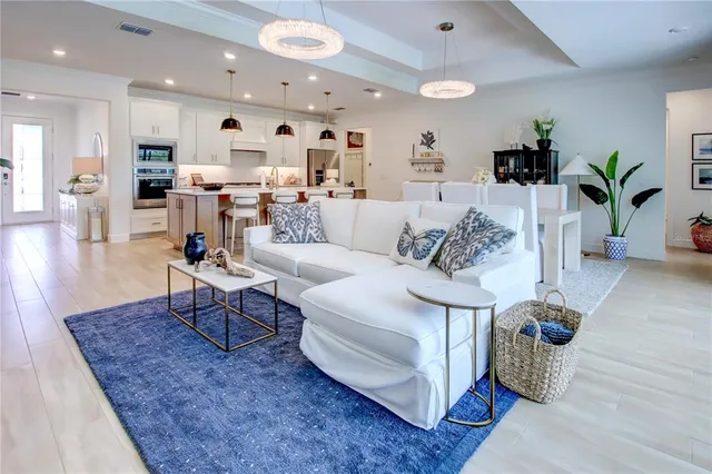 a living room with furniture kitchen and a potted plant