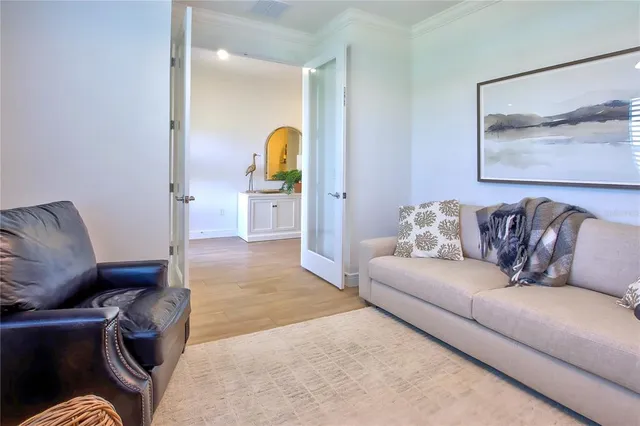 a living room with furniture and a potted plant on a stool