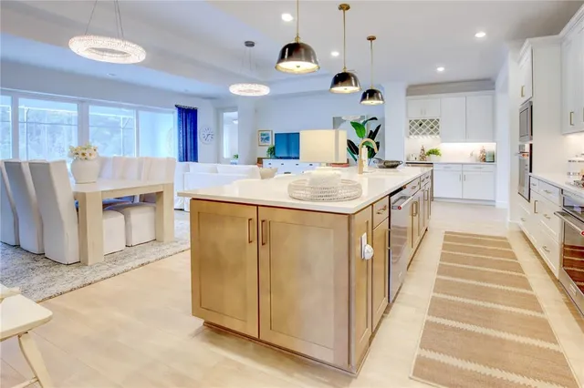 a kitchen with stainless steel appliances kitchen island granite countertop a sink and a refrigerator