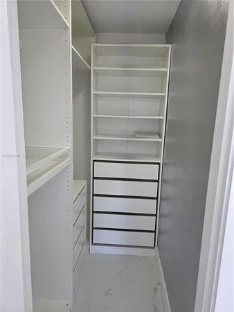 a view of walk in closet with empty racks